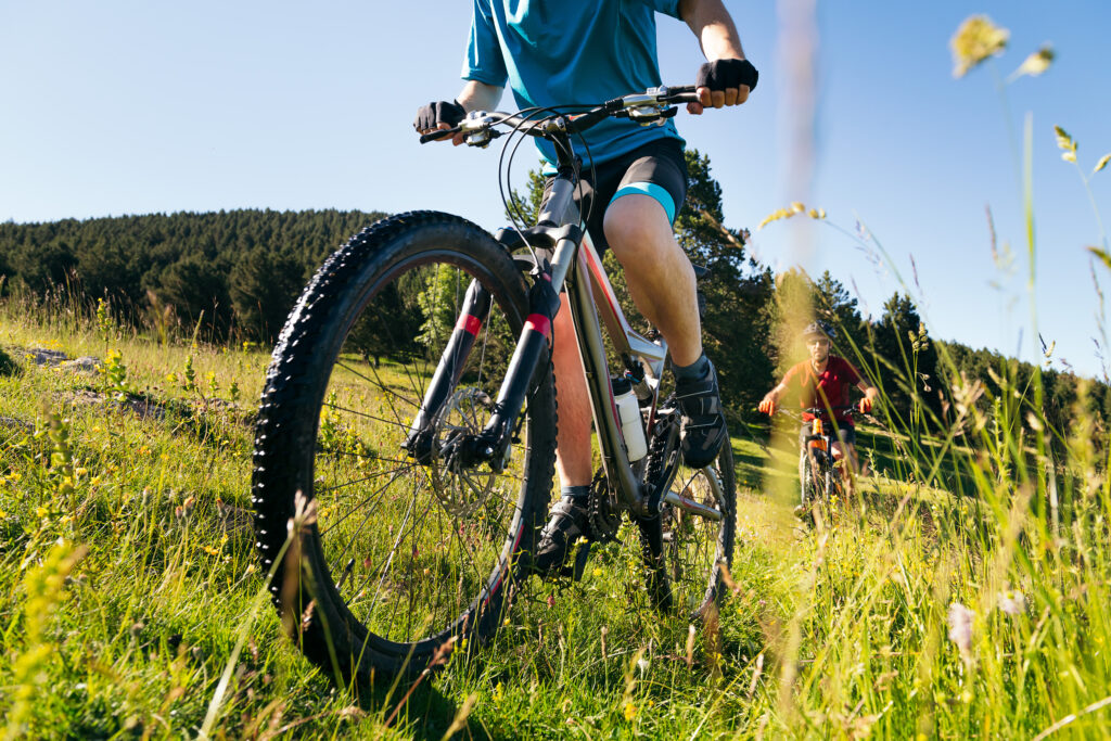 front view of two men doing sport with their bike